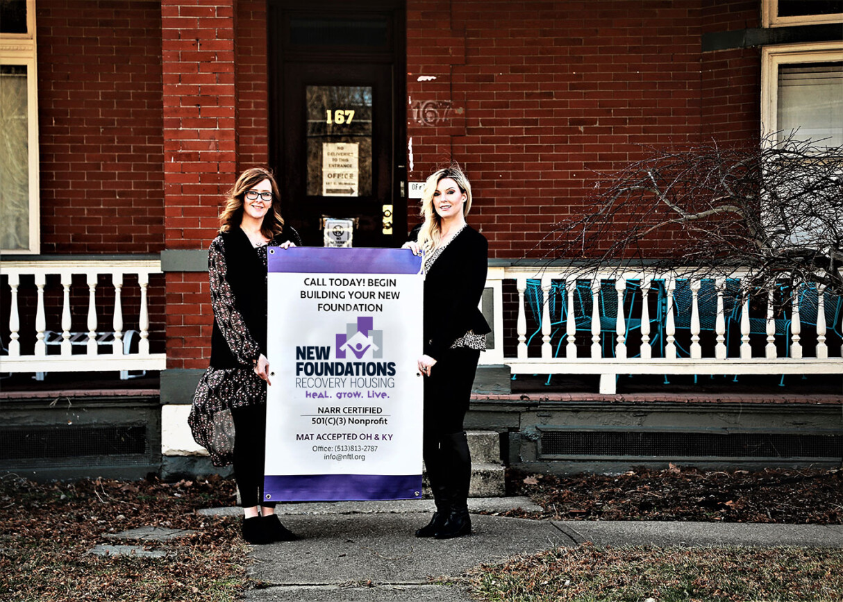 Two women holding a sign